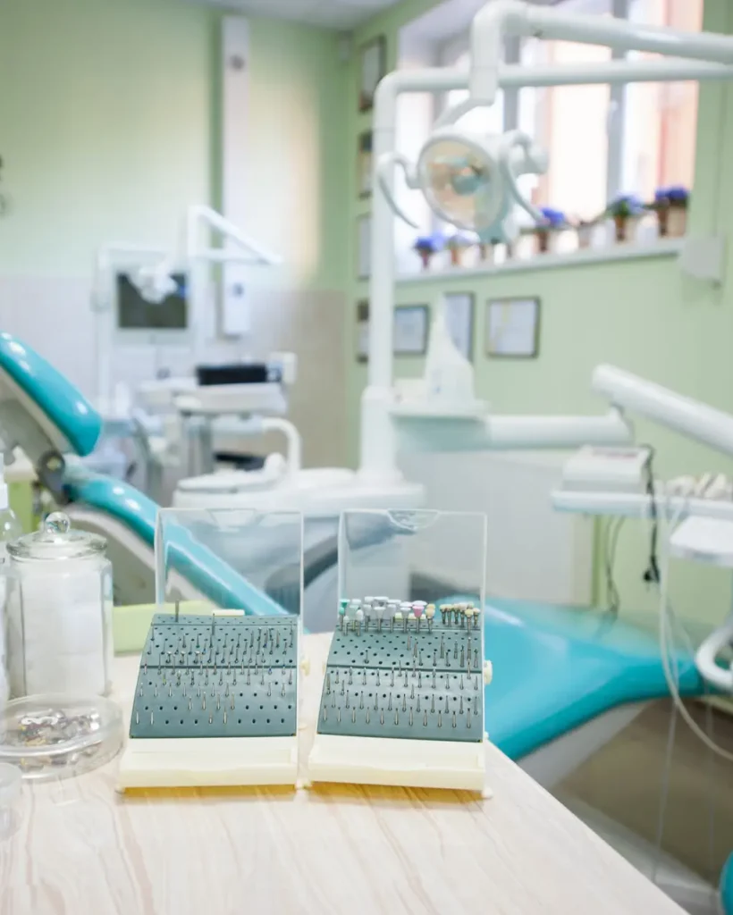 Close-up of set of different dental burs, polishing heads on the stand near dental chair in a modern stomatological office